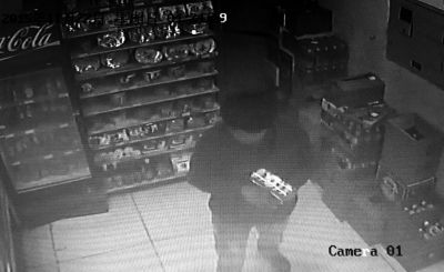 嫌疑人在便利店將貨物拿至收銀臺準(zhǔn)備搶劫。